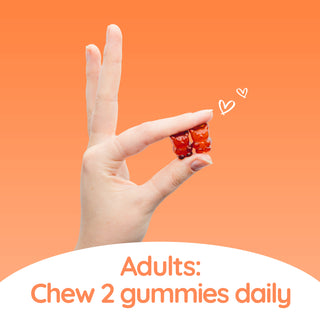 A person is holding two red Haircarebear Immune Gummies with two fingers, with the text: 'Adults: chew two gummies daily.